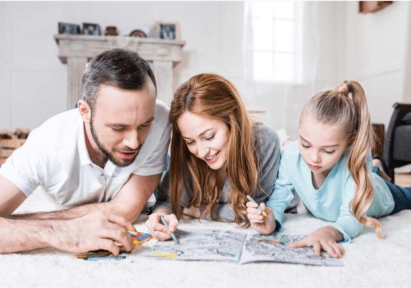 Mom dad and daughter coloring on the floor